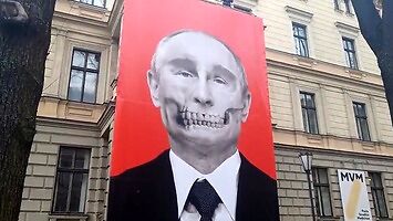 Taki plakat z Putinem zawisł naprzeciwko rosyjskiej ambasady w Rydze