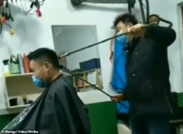 25522596-8073373-One_Chinese_barber_is_seen_using_a_long_pole_wrapped_with_a_shav-a-39_1583319534237.jpg