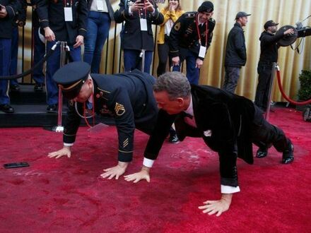 Tom Hanks i żołnierz robią pompki na czerwonym dywanie podczas rozdania Oskarów