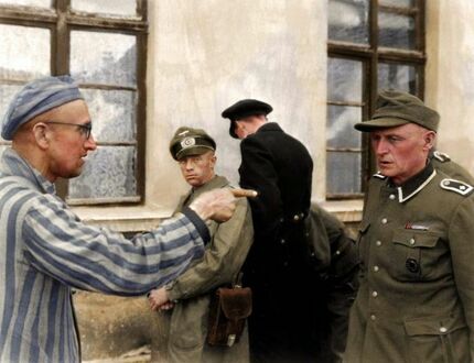 Więzień obozu koncentracyjnego w Buchenwald po wyzwoleniu wskazuje strażnika z SS, który brutalnie bił więźniów, 14 kwietnia 1945