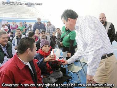Burmistrz podarowuje piłkę dziecku bez nóg