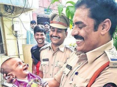 Uśmiecha się do policjantów, którzy uratowali go z rąk porywacza, Hajdarabad, Indie