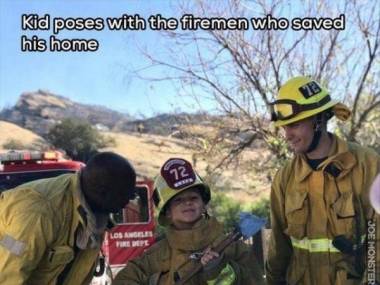 Chłopiec pozuje ze strażakami, którzy ocalili jego dom