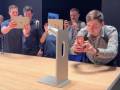Kwintesencja miłośników Apple - ludzie iPadami z zachwytem fotografują nóżkę do monitora kosztującą 1000 dolarów